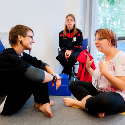 Zwei Personen unterhalten sich und eine dritte hört zu.